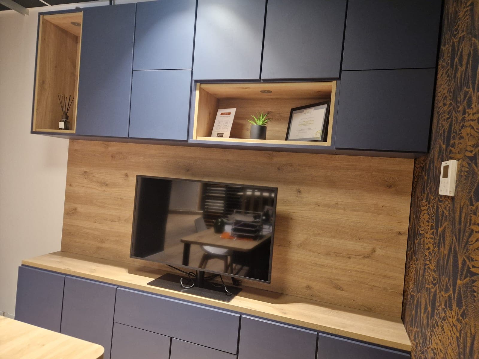 Ensemble TV complet bleu nuit et chêne naturel, meuble bas, meubles hauts et panneau TV, dans le showroom Maison Gazeau à Agen