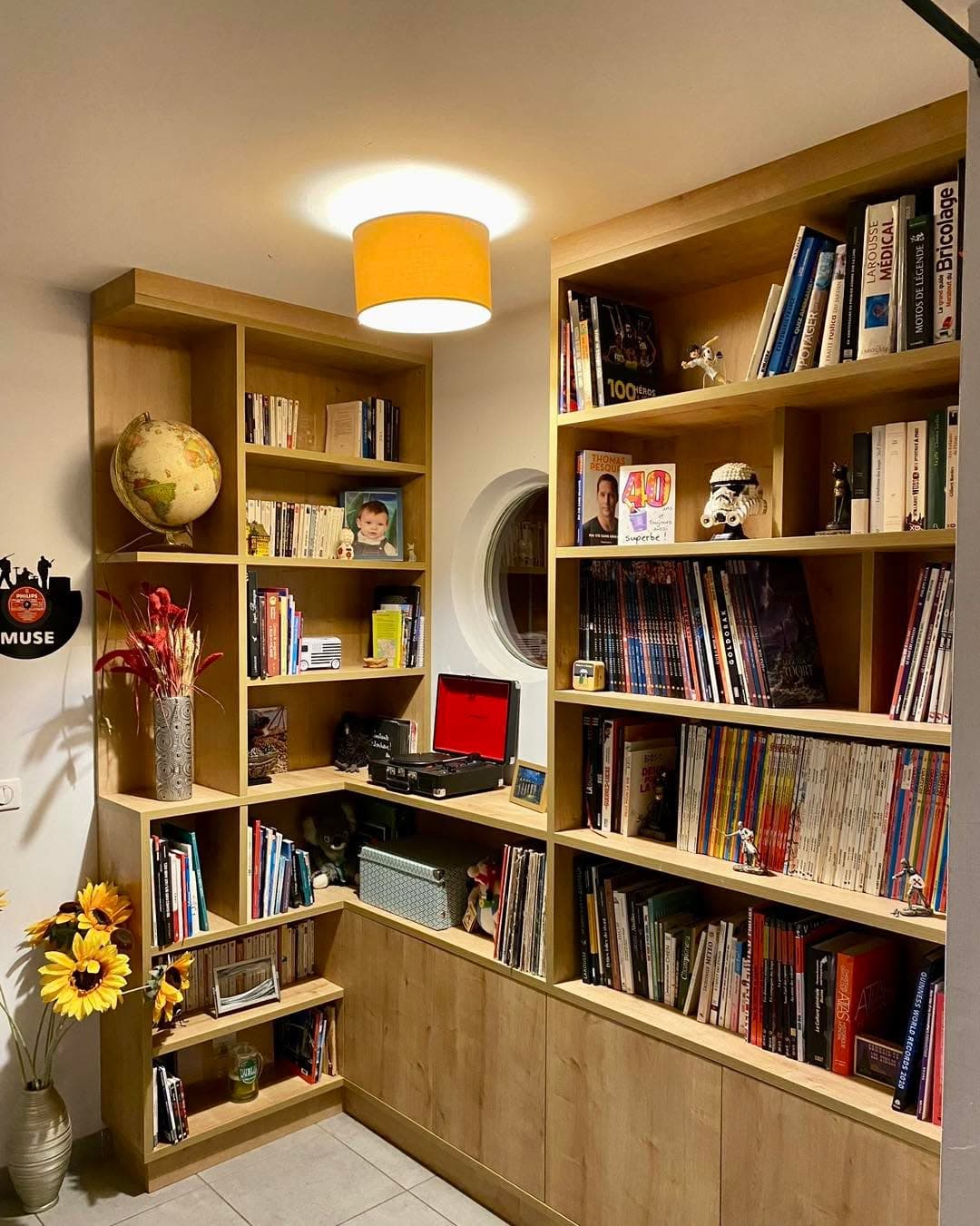 Grande bibliothèque en L en bois installée dans un angle de séjour