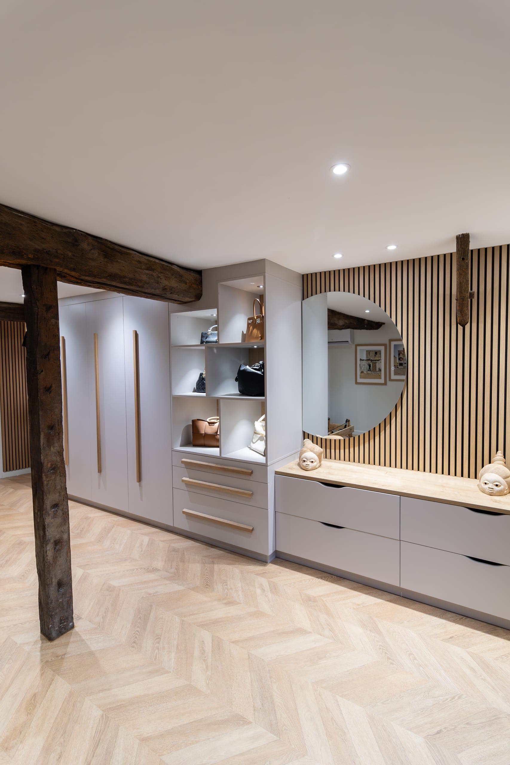 Dressing cachemire à poignées chêne, étagères ouvertes, commode à tiroirs et miroir rond sur mur tasseaux