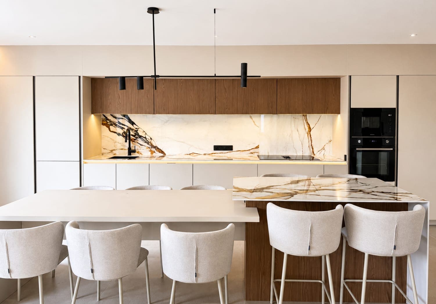 Cuisine sur mesure dans un pavillon neuf à Tarnos, façades blanches, meubles hauts bois et crédence effet marbre