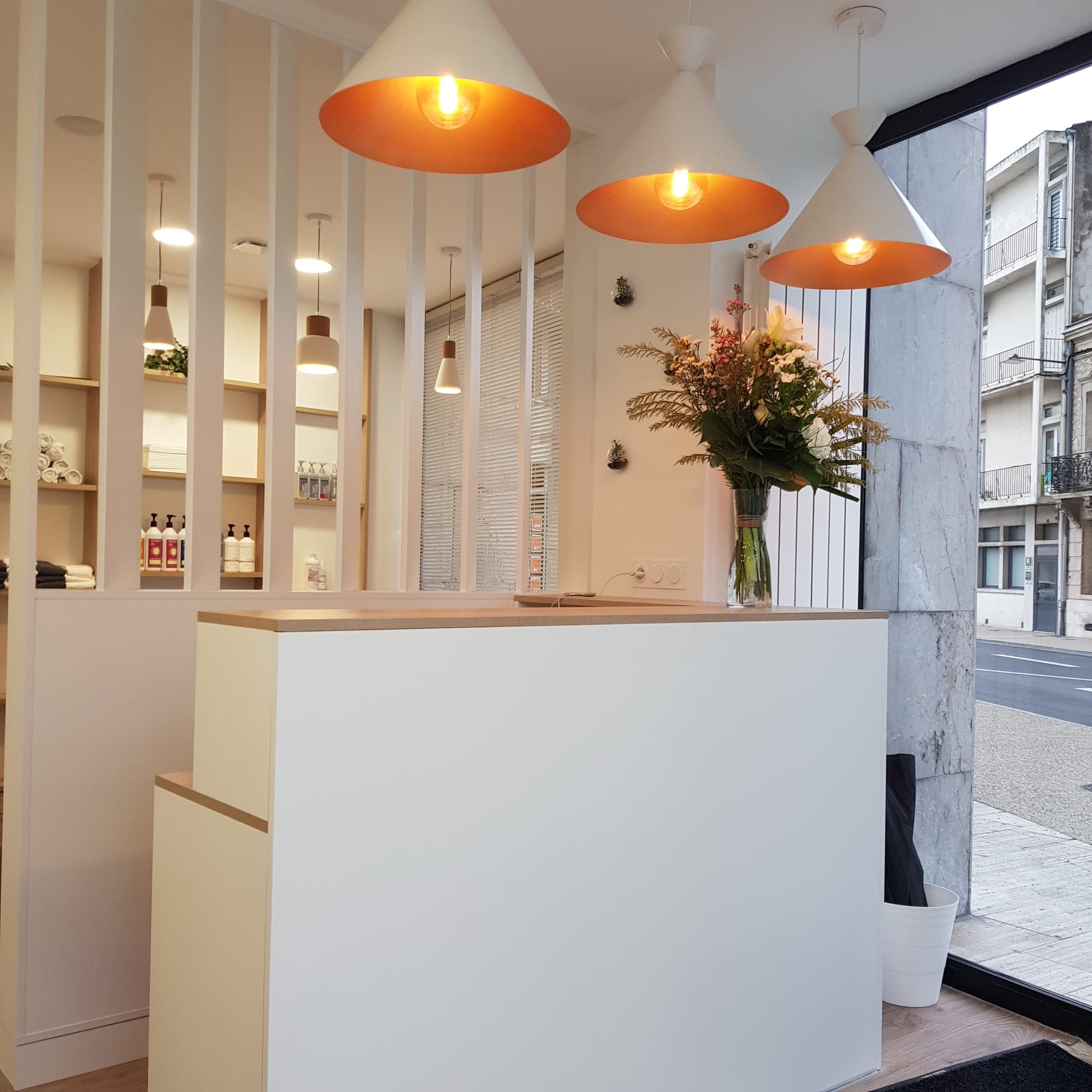 Verrière claustra toute hauteur à soubassement plein et lames blanches séparant l’accueil de l’espace shampoing dans un salon de coiffure à Agen