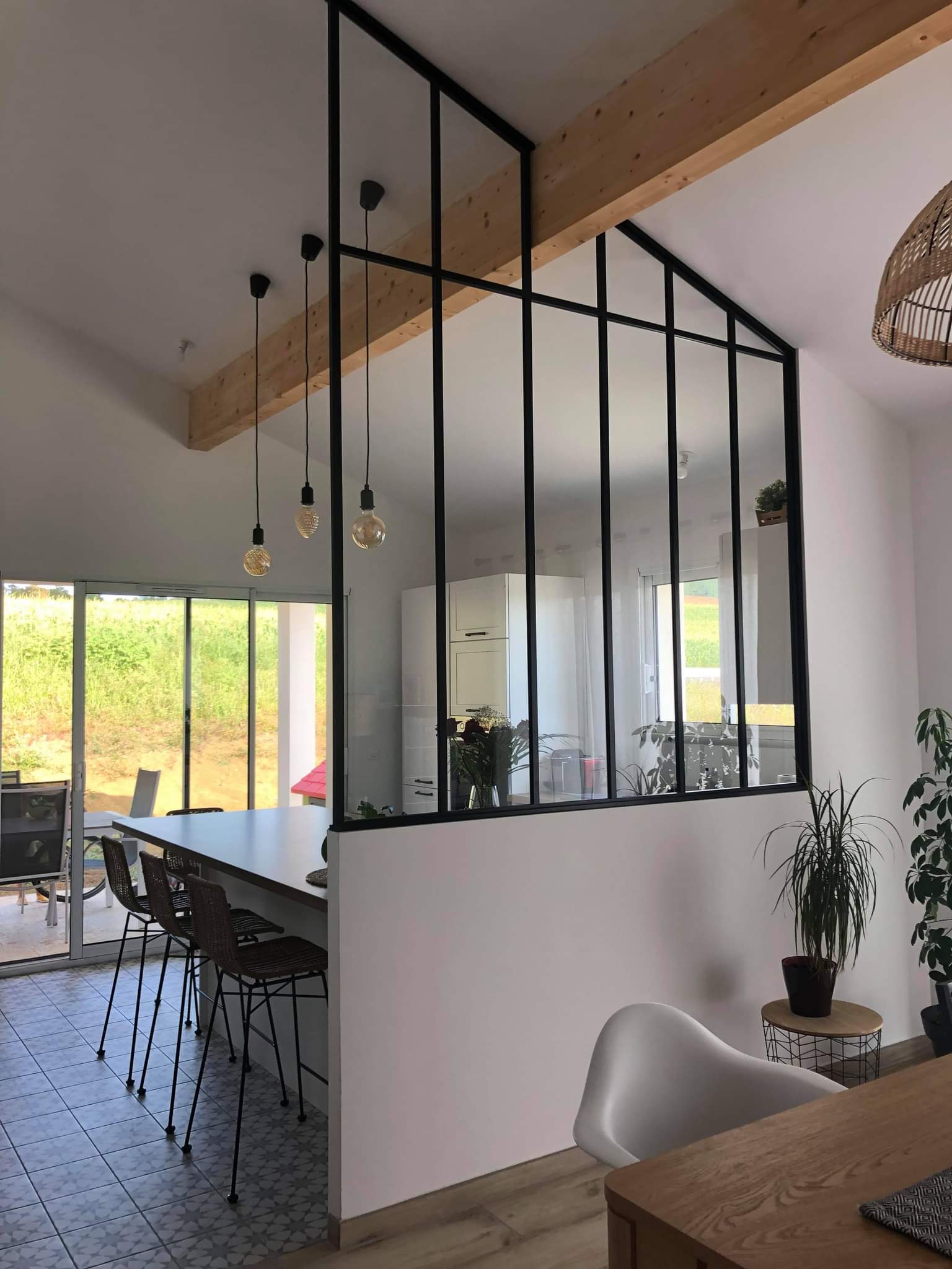 Verrière sous pente en aluminium séparant la cuisine du séjour avec poutre traversante apparente dans un pavillon à Nérac